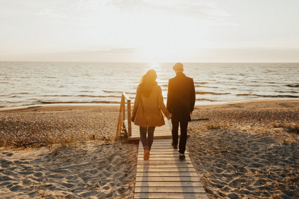 um-casal-caminhando-na-praia-em-um-dia-frio