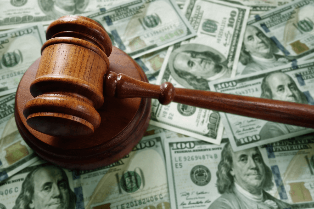 Como declarar ganhos e manter a legalidade no mercado adulto Martelo de juiz em madeira repousando sobre uma pilha de notas de cem dólares, simbolizando a legalidade dos ganhos e a necessidade de regularização fiscal para criadores de conteúdo adulto.