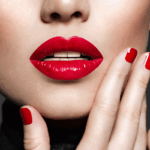 Close sensual de lábios com batom vermelho intenso e unhas pintadas, ilustrando a estética de marketing visual necessária para autores que buscam rentabilizar com contos eróticos no mercado digital.