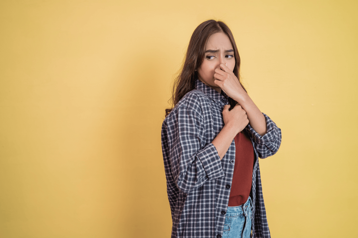 O impacto negativo do mau cheiro e desleixo na sedução Mulher expressando nojo e tapando o nariz devido ao mau odor, ilustrando como o descuido pessoal e a falta de asseio destroem a atração instantaneamente.