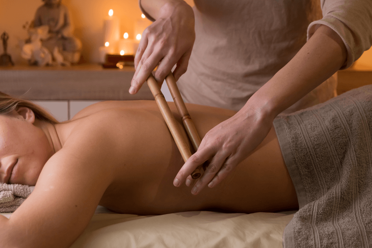 Aplicação de rolos de bambu sobre a pele das costas, demonstrando a necessidade de elasticidade tecidual e o risco de lesão em casos de pele senil ou flacidez excessiva.