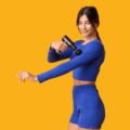 Mulher com roupa esportiva azul aplicando pistola massageadora no braço em fundo amarelo, ilustrando o guia sobre quantos minutos devo usar o massageador elétrico com segurança.