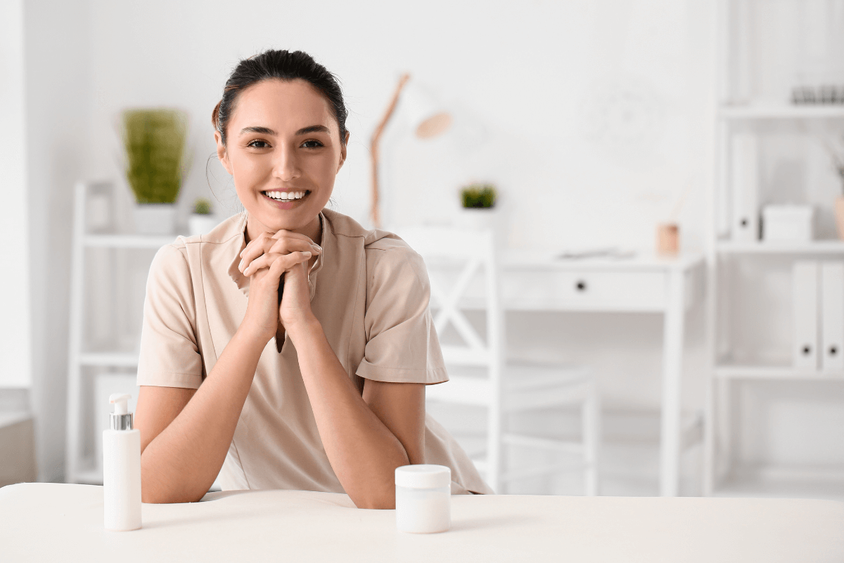 Relação de confiança: O sigilo profissional na massoterapia Massagista profissional sorrindo com postura acolhedora e de escuta no consultório, representando a ética de sigilo e confidencialidade das informações do paciente.